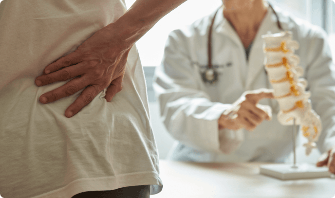 Doctor explaining treatment options to patient with spine model