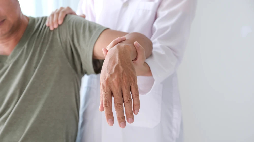 Pain specialist assessing a patient for persistent shoulder pain after injury recovery