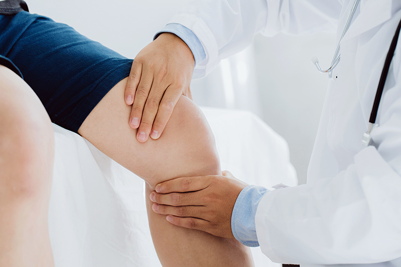 Patient consulting a knee pain specialist in clinic for assessment and treatment advice.