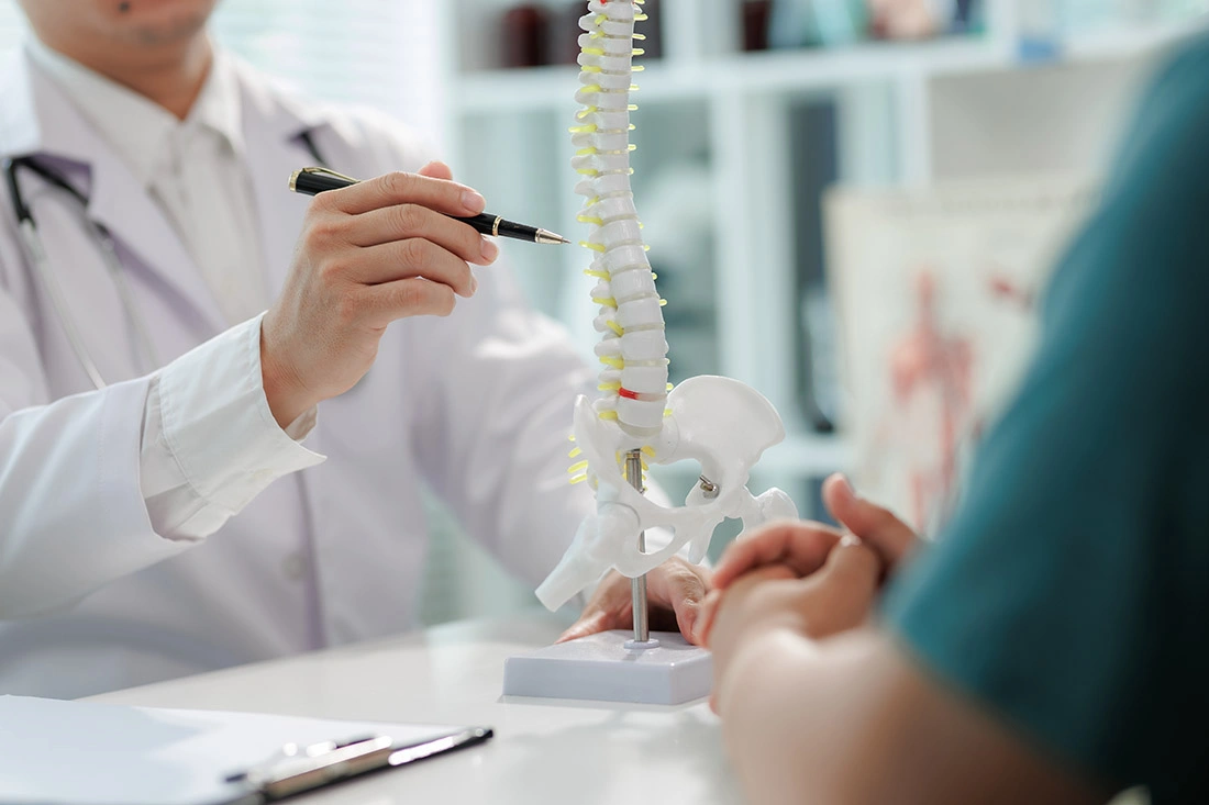 Patient sitting with a doctor during a consultation about chronic back pain.