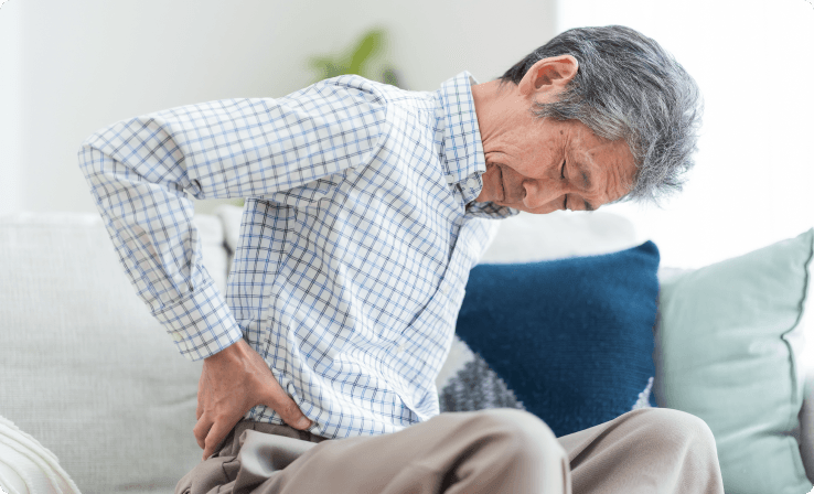 Person demonstrating poor posture at desk, a common risk factor for neck pain