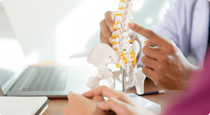Doctor explaining treatment options to patient with spine model