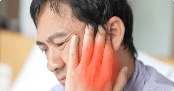 Person demonstrating poor posture at desk, a common risk factor for neck pain